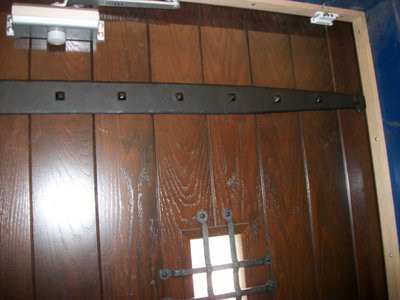 Porte en bois avec pentures et grille en fer forgé