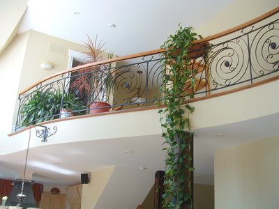 Garde-corps de mezzanine avec motifs en spirale et main courante en bois